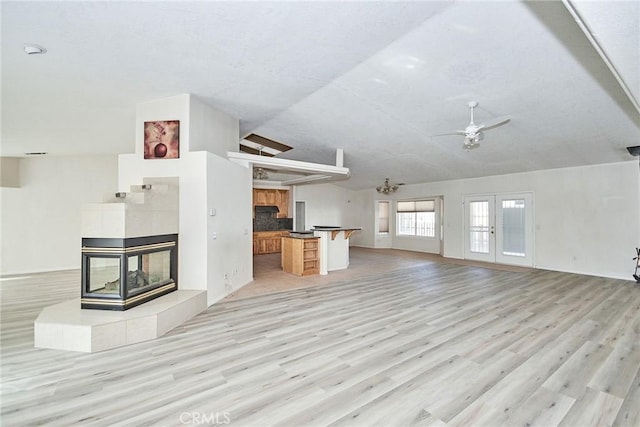 9920 Sage St, Oak Hills, CA 92344 - unfurnished living room featuring ceiling fan, a fireplace, light wood-style flooring, vaulted ceiling, and baseboards