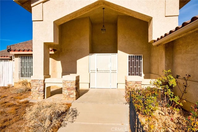 9920 Sage St, Oak Hills, CA 92344 - doorway to property featuring stucco siding and a tile roof