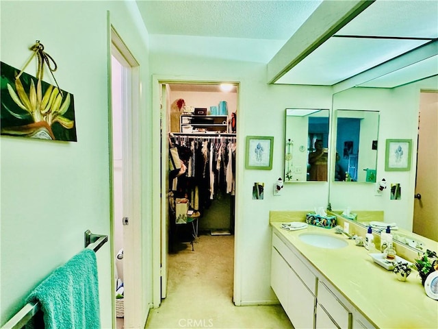 4 Camphor S, Irvine, CA 92612 - bathroom featuring vanity, a walk in closet, and a textured ceiling