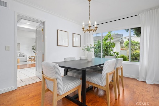 43 W Yale Loop Unit 29, Irvine, CA 92604 - dining area featuring a chandelier, plenty of natural light, ornamental molding, and light wood finished floors