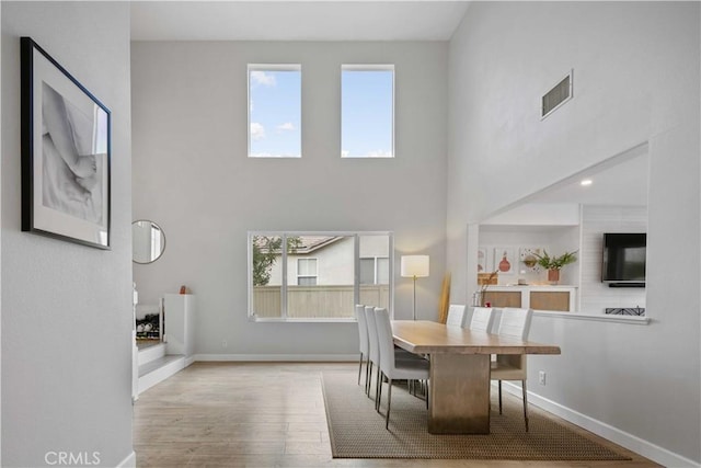 17913 Maplehurst Pl, Canyon Country, CA 91387 - dining area featuring a towering ceiling, healthy amount of natural light, wood finished floors, and baseboards