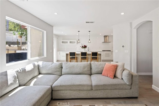 17913 Maplehurst Pl, Canyon Country, CA 91387 - living room featuring arched walkways, wood finished floors, recessed lighting, and baseboards