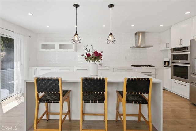 17913 Maplehurst Pl, Canyon Country, CA 91387 - kitchen with wall chimney range hood, tasteful backsplash, double oven, light countertops, and recessed lighting