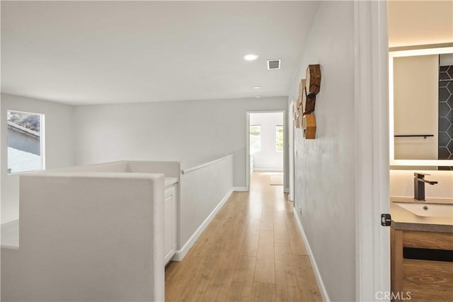 17913 Maplehurst Pl, Canyon Country, CA 91387 - hallway featuring a sink, light wood-type flooring, baseboards, and recessed lighting