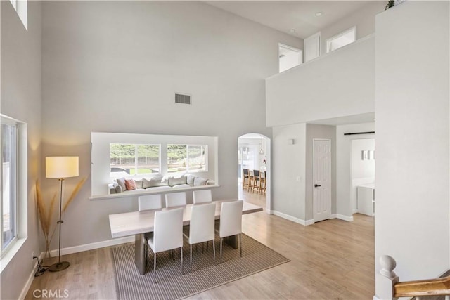 17913 Maplehurst Pl, Canyon Country, CA 91387 - dining room with a towering ceiling, arched walkways, light wood finished floors, and baseboards