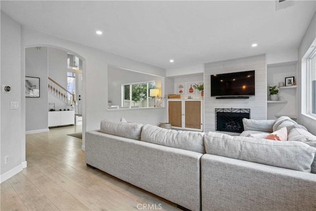 17913 Maplehurst Pl, Canyon Country, CA 91387 - living room with a fireplace, stairs, recessed lighting, arched walkways, and light wood-style floors