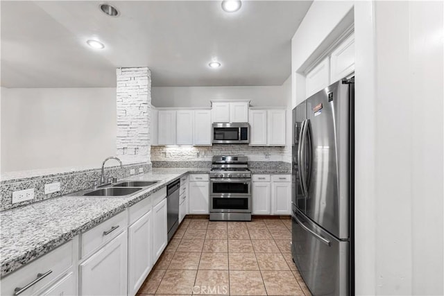 2904 Granite Ridge Pl, Bakersfield, CA 93313 - kitchen featuring appliances with stainless steel finishes, a sink, white cabinetry, backsplash, and light stone counters