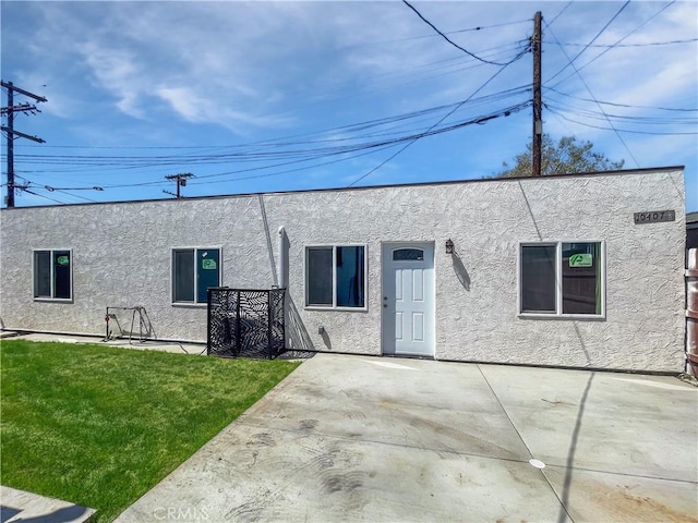 10405 S Hoover St, Los Angeles, CA 90044 - back of property with stucco siding, a lawn, and a patio
