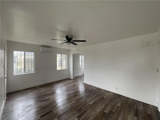 10405 S Hoover St, Los Angeles, CA 90044 - spare room featuring an AC wall unit, dark wood-style floors, a ceiling fan, and baseboards