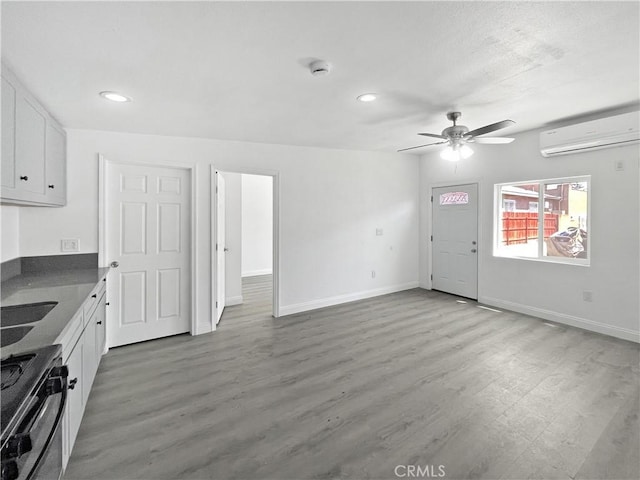 10405 S Hoover St, Los Angeles, CA 90044 - unfurnished living room with a wall mounted air conditioner, baseboards, a ceiling fan, light wood-type flooring, and recessed lighting