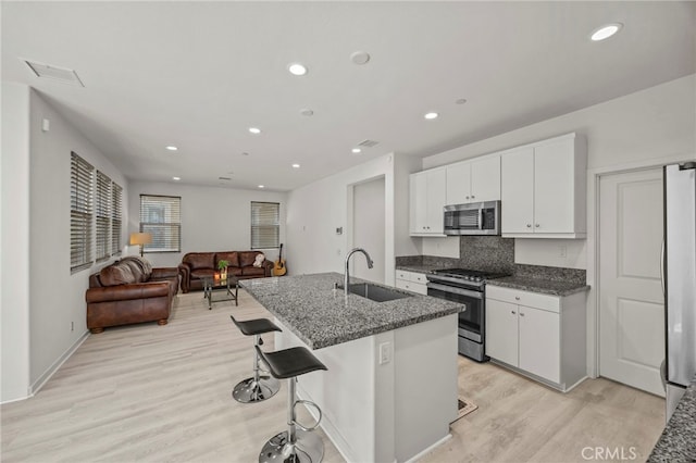 16145 Sandpiper Ave, Chino, CA 91708 - kitchen featuring appliances with stainless steel finishes, a sink, light wood-style flooring, white cabinetry, and open floor plan