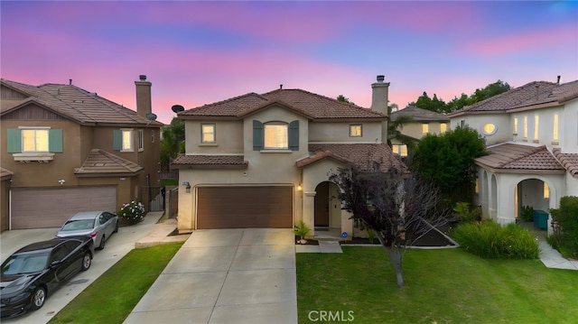 3883 Taconite Rd, San Bernardino, CA 92407 - mediterranean / spanish-style house with a garage, driveway, a tile roof, stucco siding, and a yard