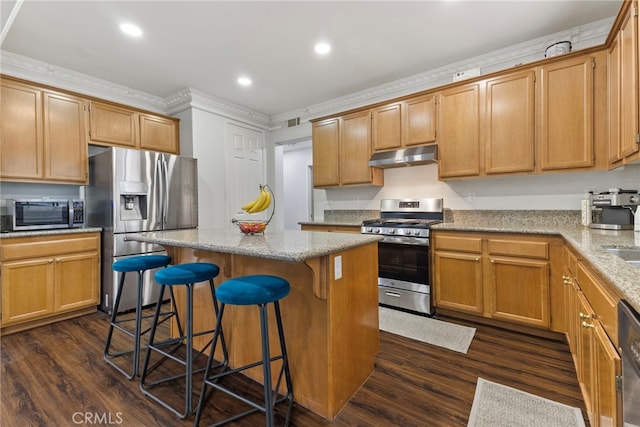 3883 Taconite Rd, San Bernardino, CA 92407 - kitchen featuring appliances with stainless steel finishes, under cabinet range hood, dark wood-type flooring, a kitchen island, and a breakfast bar area