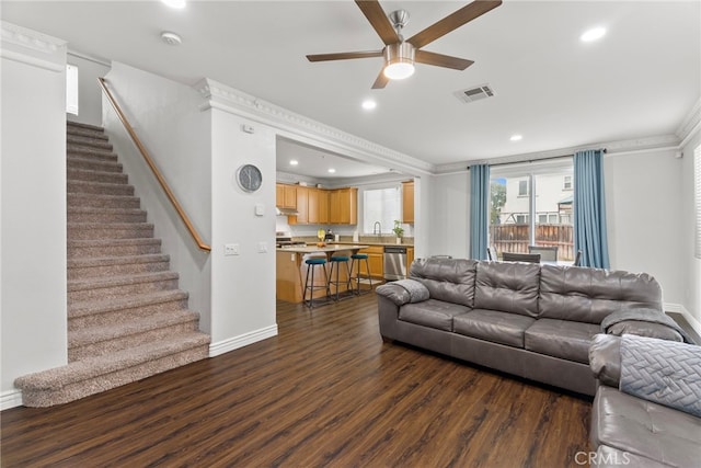 3883 Taconite Rd, San Bernardino, CA 92407 - living area with crown molding, dark wood-style floors, a ceiling fan, stairs, and recessed lighting