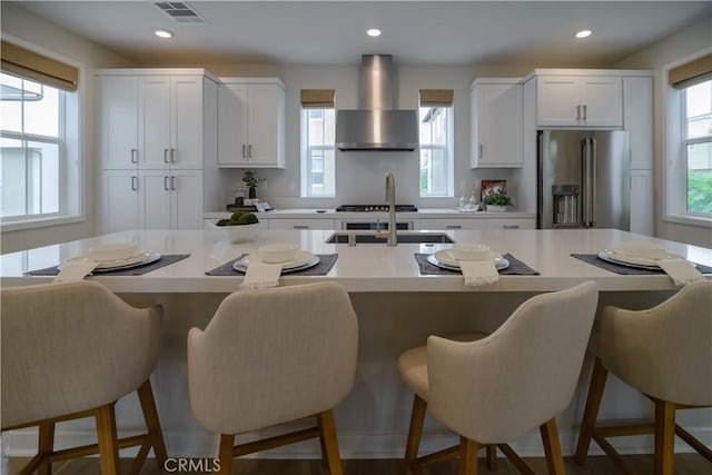 21 Welltree Way, Rancho Mission Viejo, CA 92694 - kitchen featuring high end refrigerator, wall chimney exhaust hood, white cabinets, light countertops, and recessed lighting