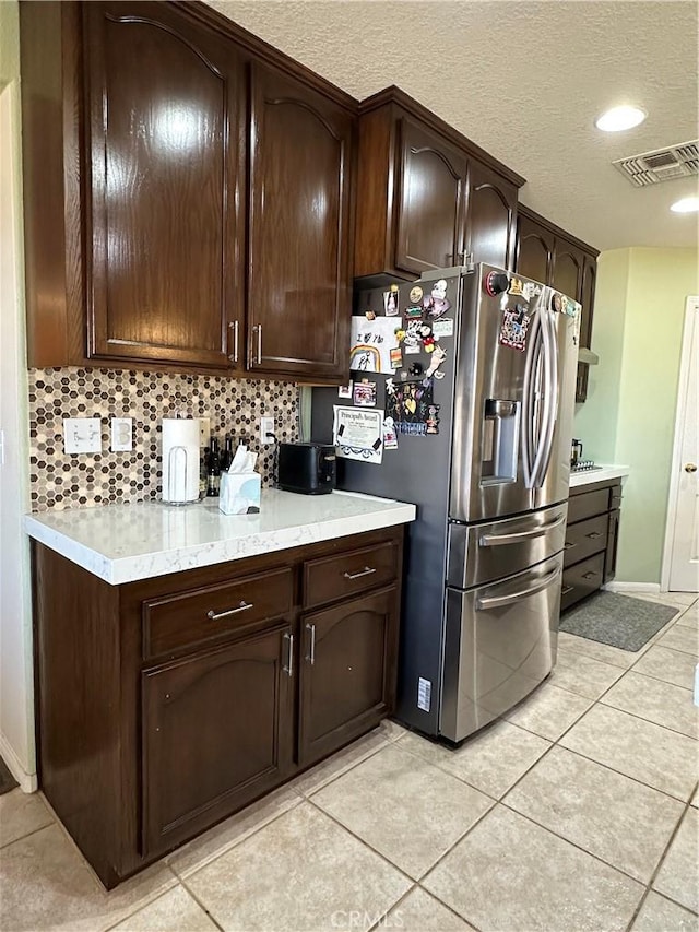 8843 San Diego Dr, Yucca Valley, CA 92284 - kitchen with stainless steel fridge with ice dispenser, light countertops, dark brown cabinets, light tile patterned flooring, and a textured ceiling