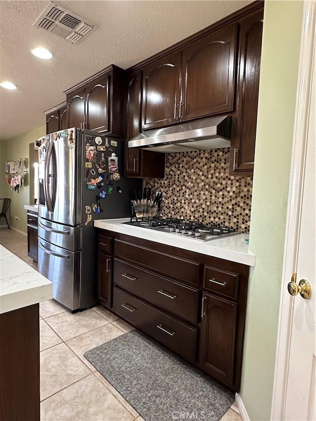 8843 San Diego Dr, Yucca Valley, CA 92284 - kitchen featuring under cabinet range hood, appliances with stainless steel finishes, light countertops, backsplash, and dark brown cabinetry