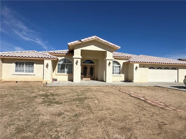 8843 San Diego Dr, Yucca Valley, CA 92284 - rear view of property with an attached garage, stucco siding, a tiled roof, and french doors