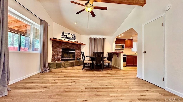 2051 6th Ln, Big Bear, CA 92314 - dining area featuring light wood-style flooring, lofted ceiling, a ceiling fan, a stone fireplace, and baseboards