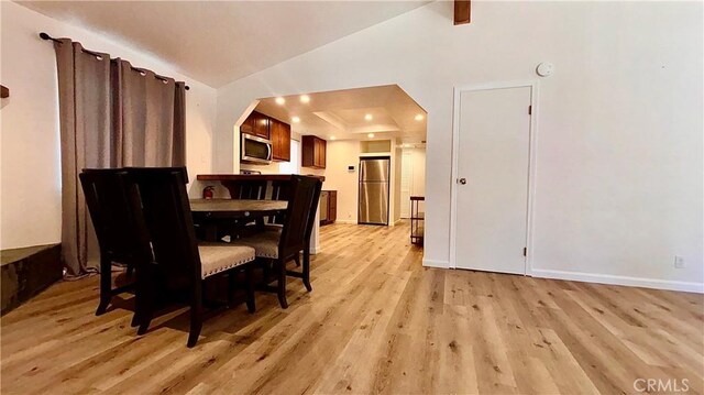 2051 6th Ln, Big Bear, CA 92314 - dining room with light wood-type flooring, lofted ceiling, baseboards, arched walkways, and a tray ceiling