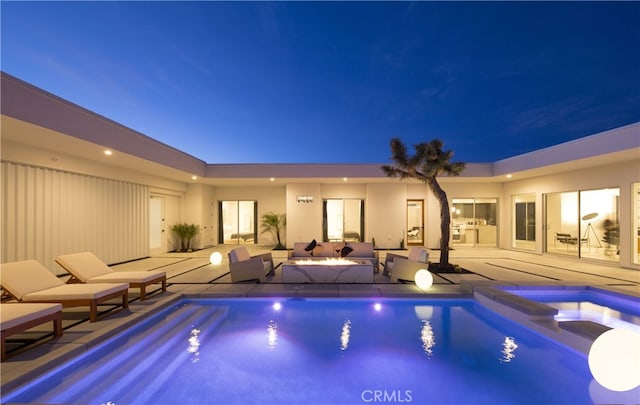 7035 Sunny Vista Rd, Joshua Tree, CA 92252 - pool at night featuring an outdoor living space, a patio area, and a pool with connected hot tub