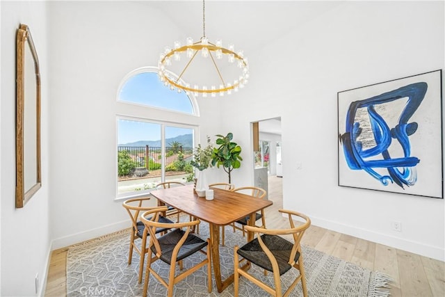 23 Santa Isabel, Rancho Santa Margarita, CA 92688 - dining area featuring a chandelier, wood finished floors, baseboards, and a high ceiling