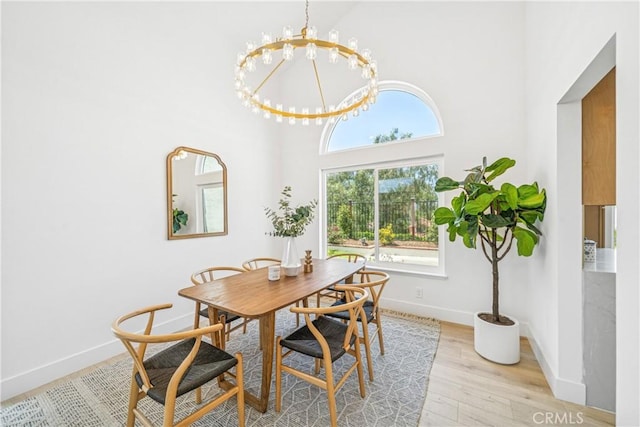 23 Santa Isabel, Rancho Santa Margarita, CA 92688 - dining room with healthy amount of natural light, light wood-type flooring, baseboards, a towering ceiling, and a chandelier