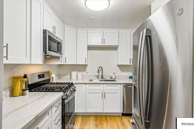 9950 Durant Dr Unit 209, Beverly Hills, CA 90212 - kitchen featuring appliances with stainless steel finishes, a sink, white cabinets, and light wood-style flooring