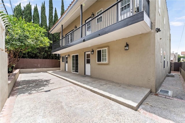 1960 Chariton St, Los Angeles, CA 90034 - back of property with stucco siding, a balcony, and a patio