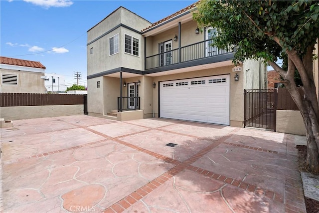 1960 Chariton St, Los Angeles, CA 90034 - view of front of property featuring a balcony, stucco siding, driveway, a garage, and a gate