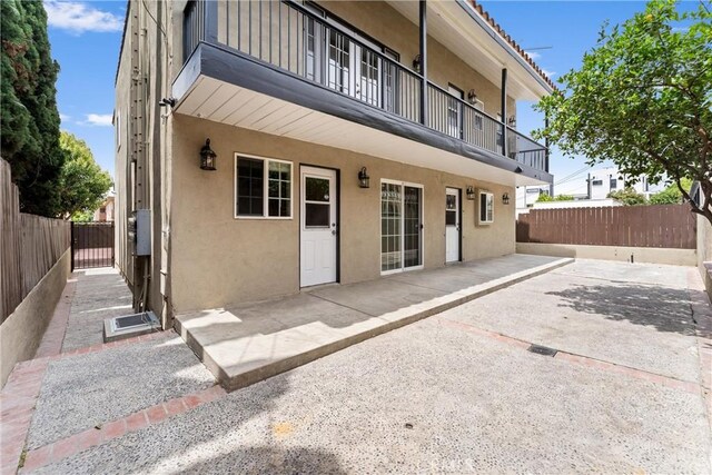 1960 Chariton St, Los Angeles, CA 90034 - back of property featuring stucco siding, a balcony, and a patio area