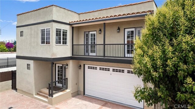 1960 Chariton St, Los Angeles, CA 90034 - view of front of house featuring stucco siding, a balcony, an attached garage, and a tile roof