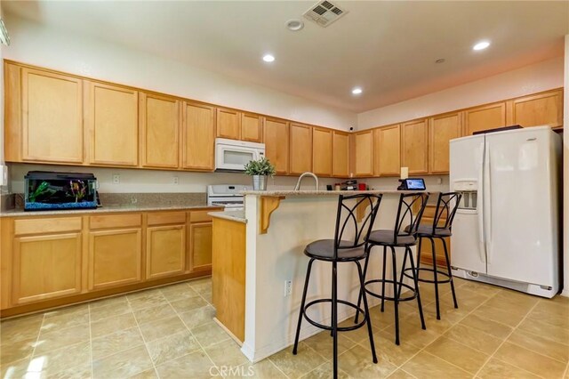 16710 Nicklaus Dr Unit 73, Rancho Cascades, CA 91342 - kitchen featuring white appliances, a center island with sink, a kitchen bar, recessed lighting, and light brown cabinetry