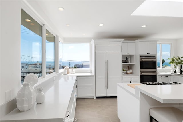 420 34th St, Manhattan Beach, CA 90266 - kitchen with double oven, paneled fridge, recessed lighting, white cabinets, and a breakfast bar area
