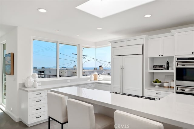 420 34th St, Manhattan Beach, CA 90266 - kitchen featuring paneled fridge, light countertops, a kitchen breakfast bar, white cabinets, and recessed lighting