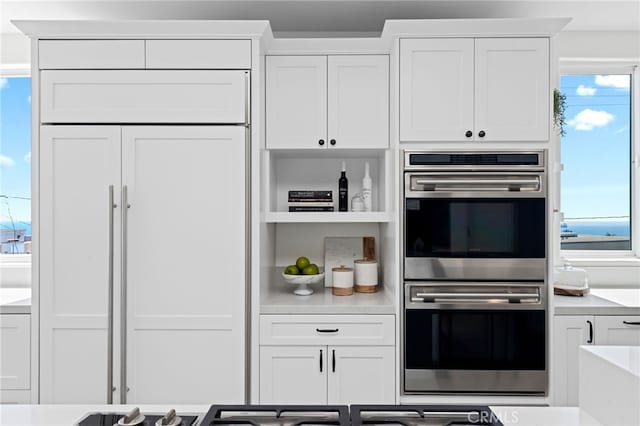 420 34th St, Manhattan Beach, CA 90266 - kitchen with double oven, paneled fridge, white cabinetry, and light countertops