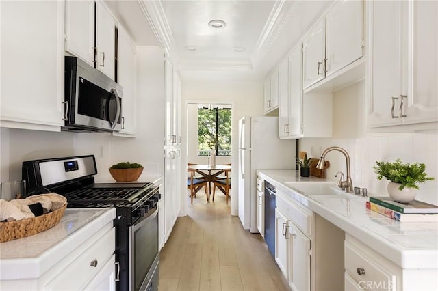 330 Cordova St Unit 322, Pasadena, CA 91101 - kitchen featuring appliances with stainless steel finishes, a sink, light wood-type flooring, white cabinets, and light countertops