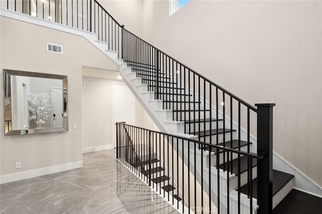 56 Claudius Ct, Irvine, CA 92618 - stairway featuring baseboards, marble tiled floors, and a towering ceiling