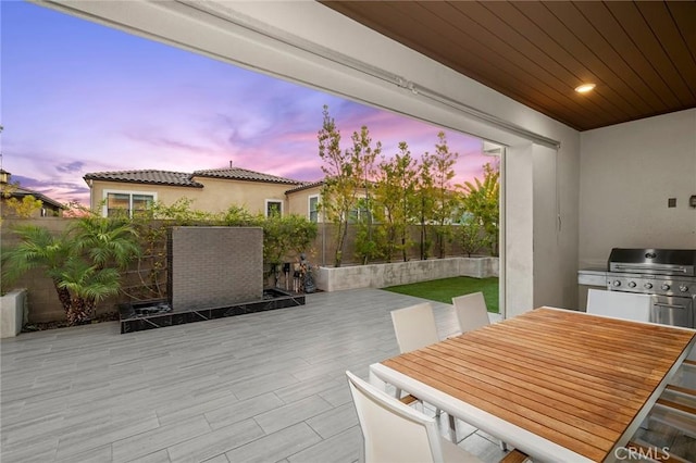 56 Claudius Ct, Irvine, CA 92618 - patio terrace at dusk featuring a fenced backyard, outdoor dining area, and a wooden deck
