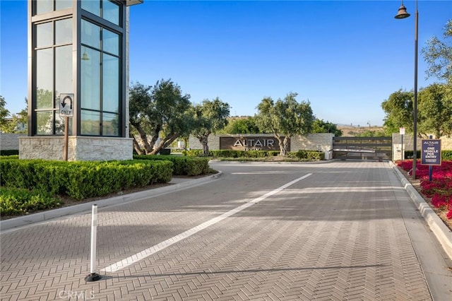 56 Claudius Ct, Irvine, CA 92618 - view of decorative road featuring curbs, street lighting, and a gate