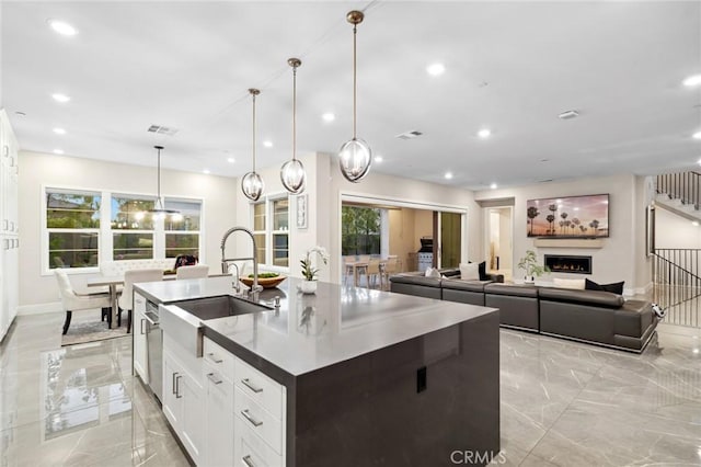 56 Claudius Ct, Irvine, CA 92618 - kitchen with a sink, light marble finish floors, an island with sink, white cabinetry, and recessed lighting