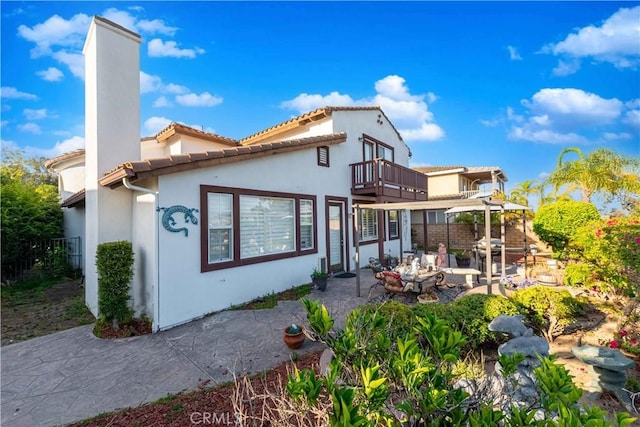 668 Corte Sol, Camarillo, CA 93010 - rear view of property featuring a balcony, a chimney, a patio, stucco siding, and a tile roof