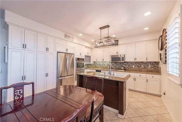 668 Corte Sol, Camarillo, CA 93010 - kitchen with stainless steel appliances, white cabinets, tasteful backsplash, a chandelier, and light tile patterned floors