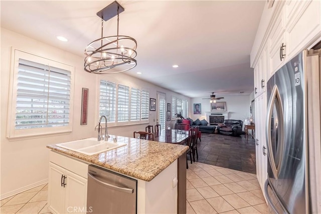 668 Corte Sol, Camarillo, CA 93010 - kitchen with stainless steel appliances, a sink, a chandelier, white cabinets, and a ceiling fan