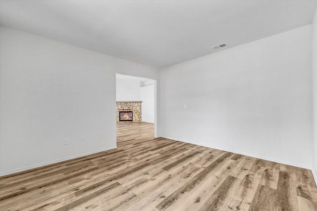 1036 W Gilman St, Banning, CA 92220 - unfurnished room featuring wood finished floors and a stone fireplace