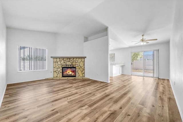 1036 W Gilman St, Banning, CA 92220 - unfurnished living room with wood finished floors, a ceiling fan, and a stone fireplace