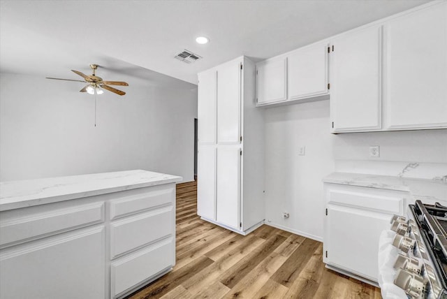 1036 W Gilman St, Banning, CA 92220 - kitchen featuring stainless steel gas range oven, a ceiling fan, white cabinets, recessed lighting, and light stone counters
