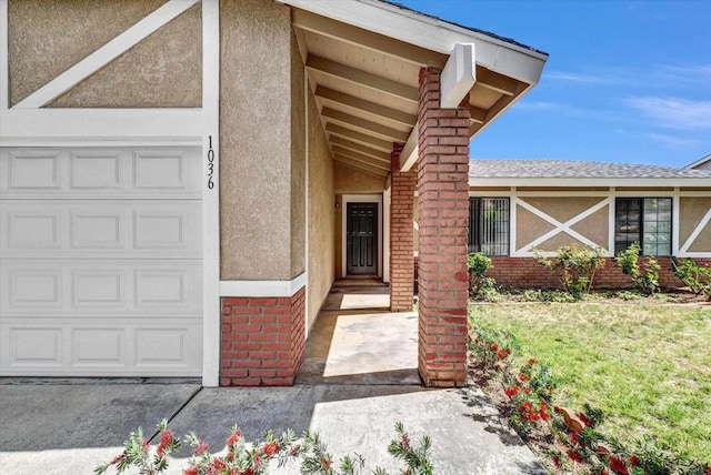 1036 W Gilman St, Banning, CA 92220 - entrance to property featuring stucco siding, brick siding, a garage, and a lawn