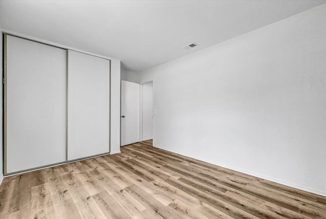 1036 W Gilman St, Banning, CA 92220 - unfurnished bedroom featuring wood finished floors and a closet