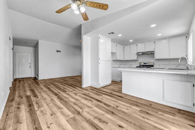 1036 W Gilman St, Banning, CA 92220 - kitchen featuring under cabinet range hood, light wood-type flooring, electric stove, light countertops, and a peninsula